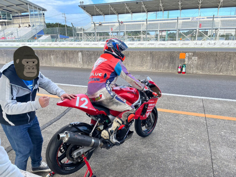 SV650Sに乗ってピットから出準備中のHさんと、後ろで支えるFさん